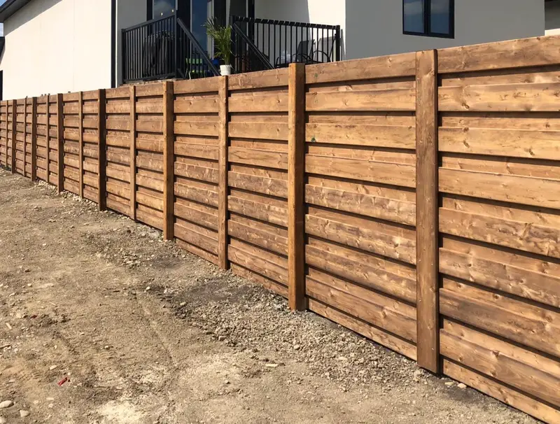 Modern Horizontal Wood Fence Modern horizontal-board wood fence with stained slats in front of a new home in Saskatoon